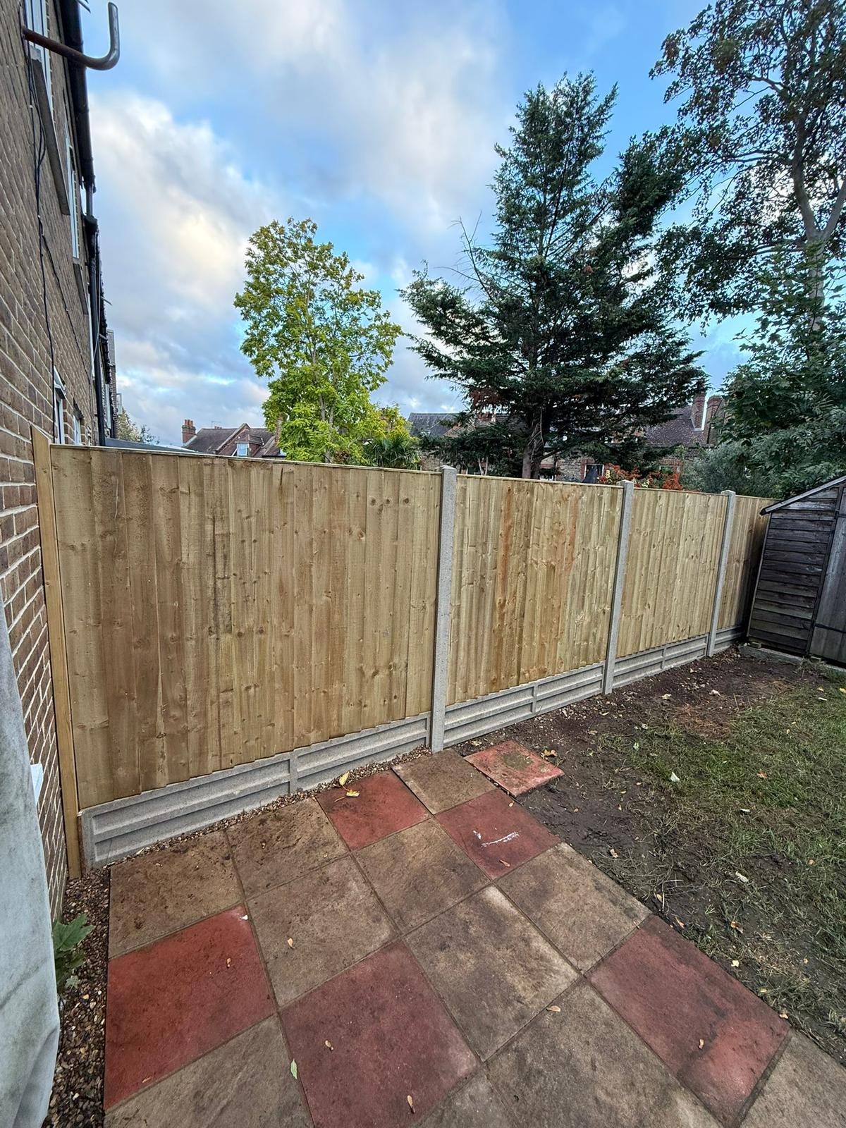 Run of timber fence panels with concrete posts and gravel boards.