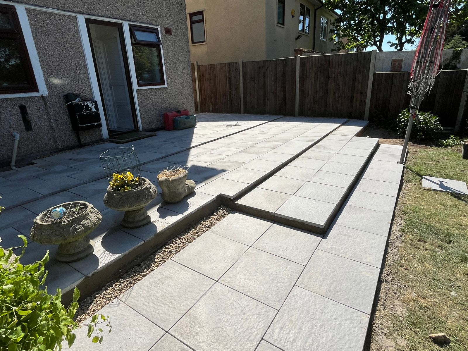 Compact garden re-shaped to create a simple seating and lawn area.