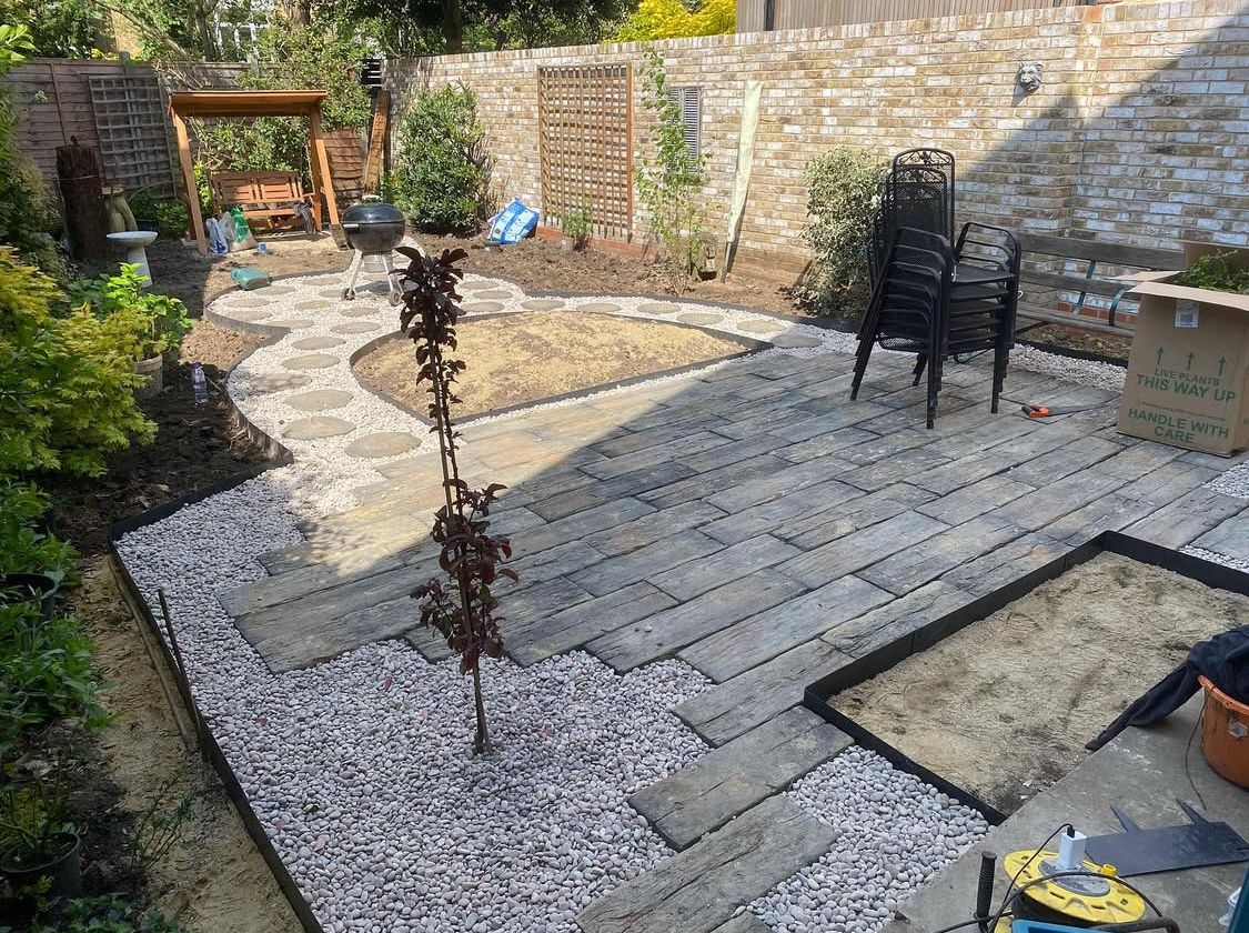 Small walled garden with curved paving and a circular feature bed.